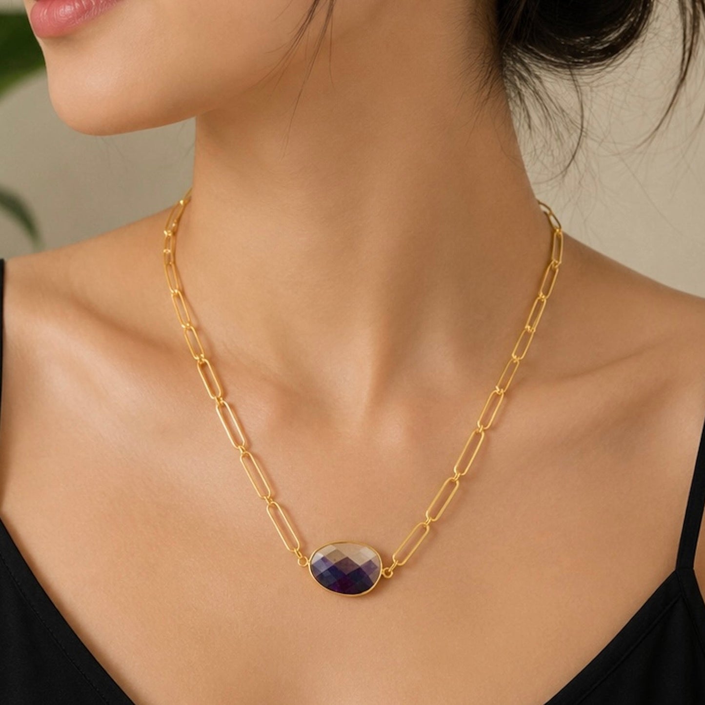 a gold chain necklace with an oval purple Amethyst stone pendant