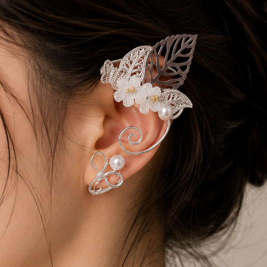 A close-up side profile of a woman with dark hair in a bun, wearing a delicate white floral and butterfly ear cuff earring.