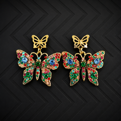 A pair of gold butterfly drop earrings embellished with multicolored rhinestones in red, green, and blue