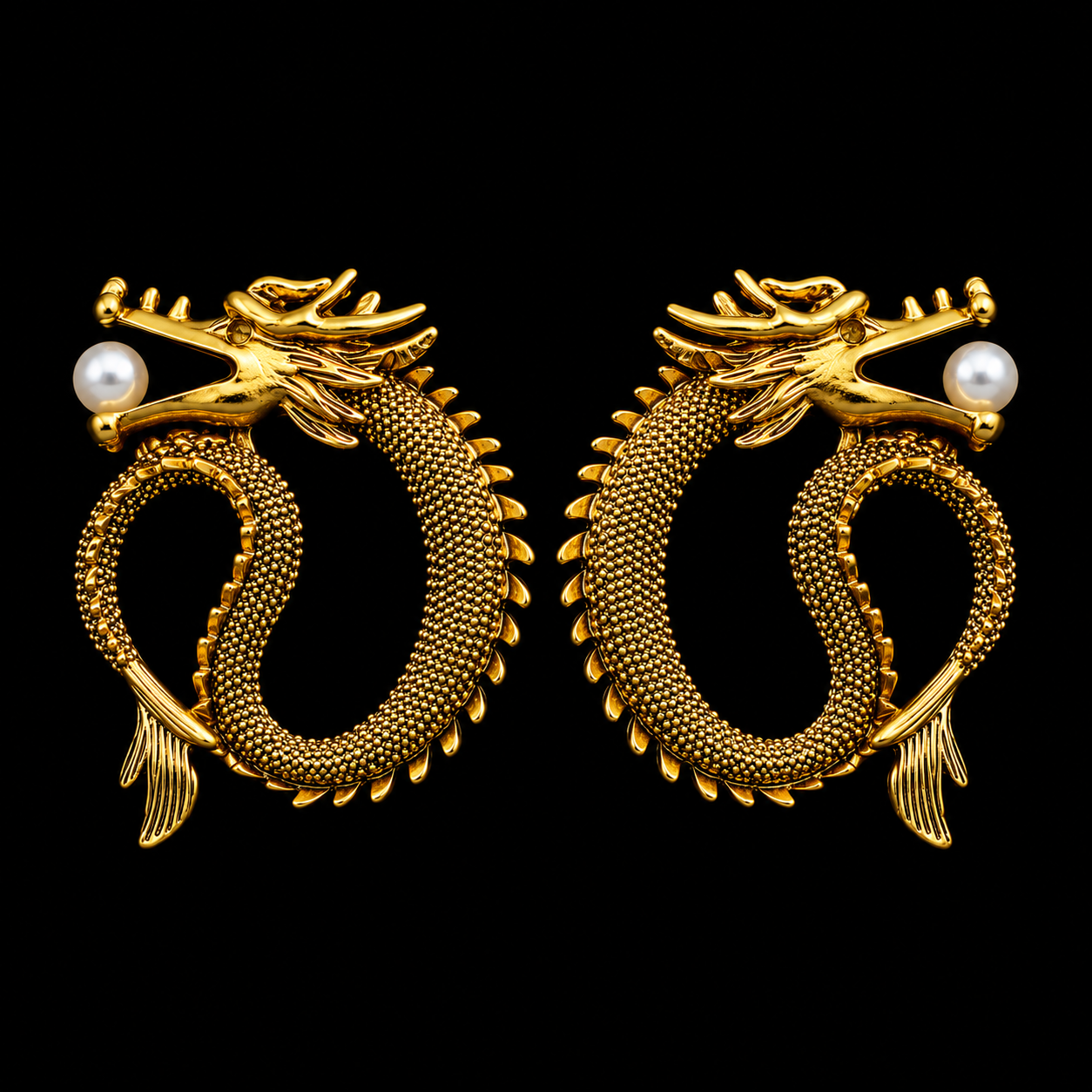 A pair of gold dragon stud earrings with textured scales, detailed heads, and a single white pearl on each side, set against a solid black background.