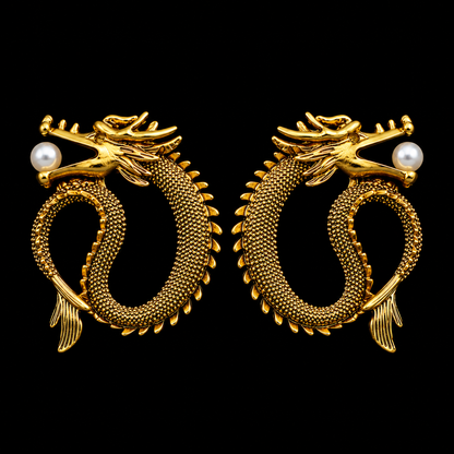 A pair of gold dragon stud earrings with textured scales, detailed heads, and a single white pearl on each side, set against a solid black background.